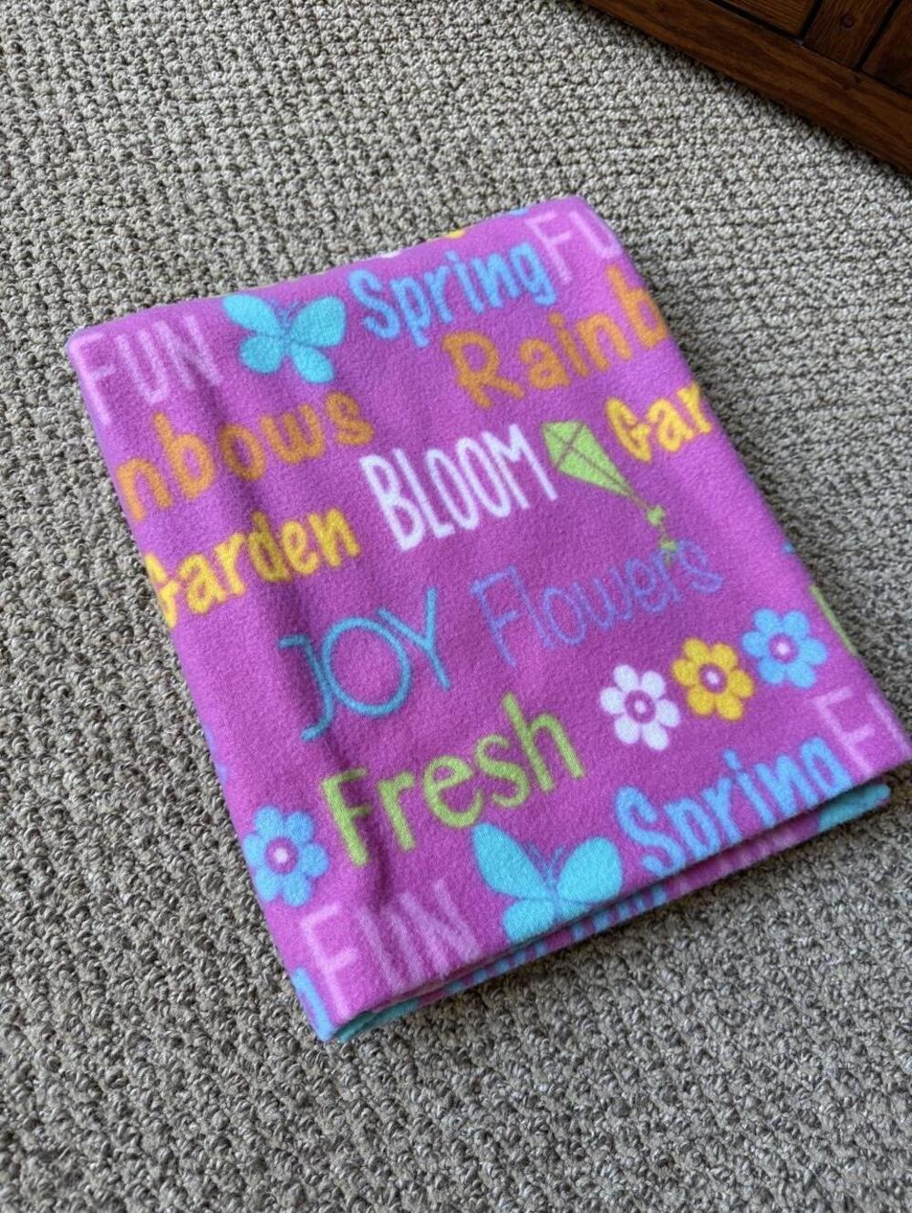 pink fleece blanket with colorful text and flowers